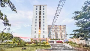 A multi-story building with a modern architectural design, featuring a prominent vertical structure on the right side.