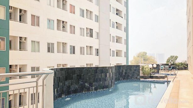 A modern apartment building with a swimming pool. - Compact And Restful Studio At Pavilion Permata Apartment (Surabaya)