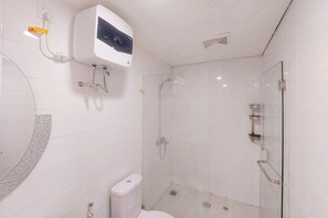 Enjoy a refreshing shower in this bathroom with a glass-enclosed shower area and wall-mounted control panel.