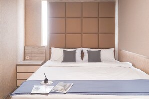 Relax in comfort with a large bed, bedside table, and lamp.