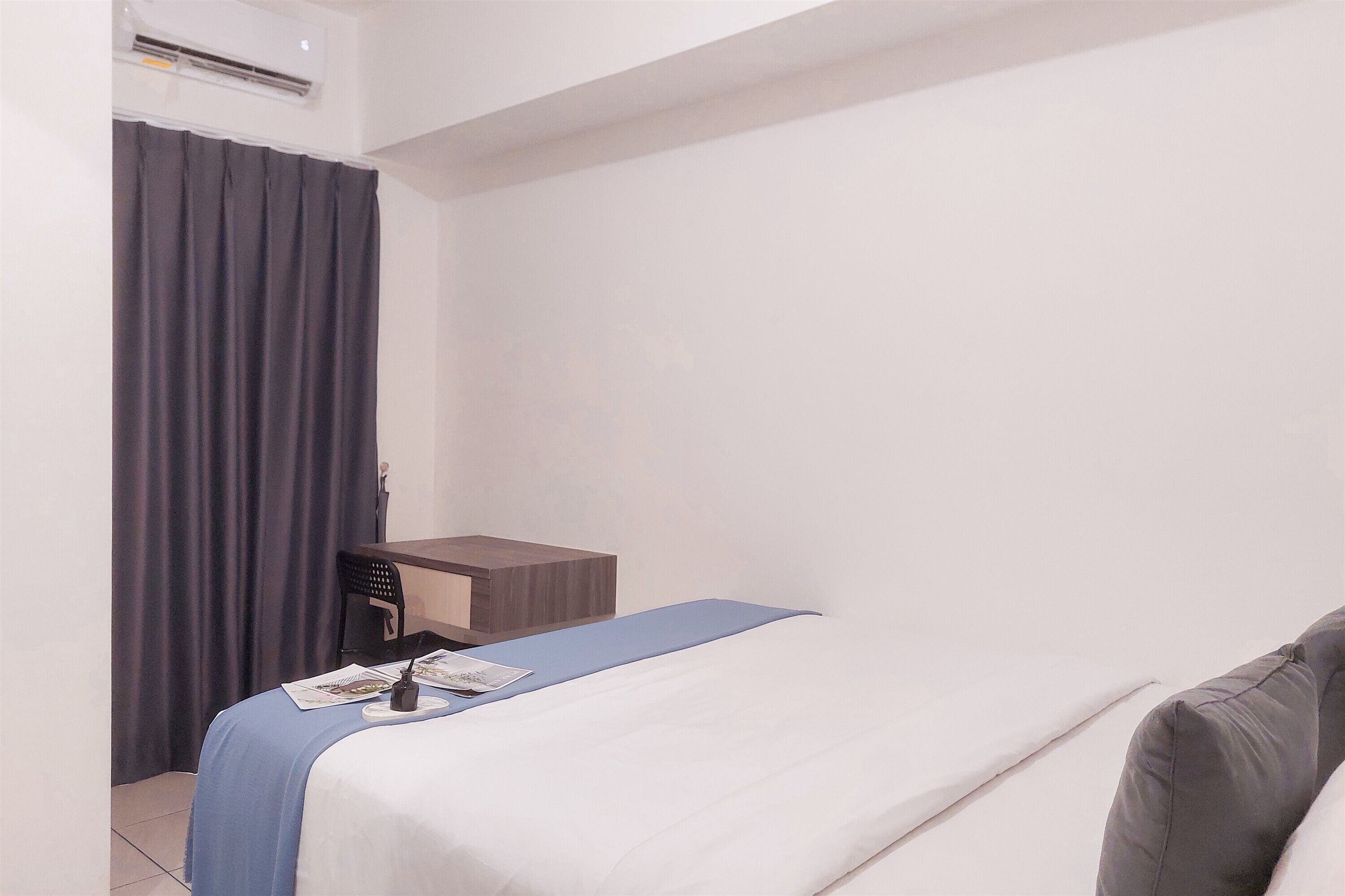 Una habitación de hotel con una cama, un escritorio y una silla.