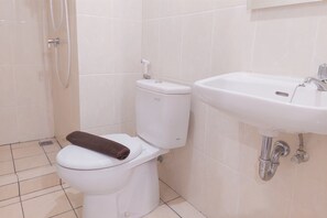 Un baño con inodoro, lavamanos y ducha.