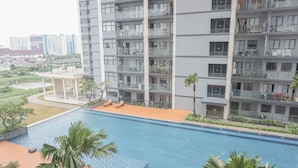 A modern hotel with a rooftop pool, multiple balconies, and a view of the cityscape. - Cozy And Spacious Studio At Daan Mogot City Apartment (Jakarta)