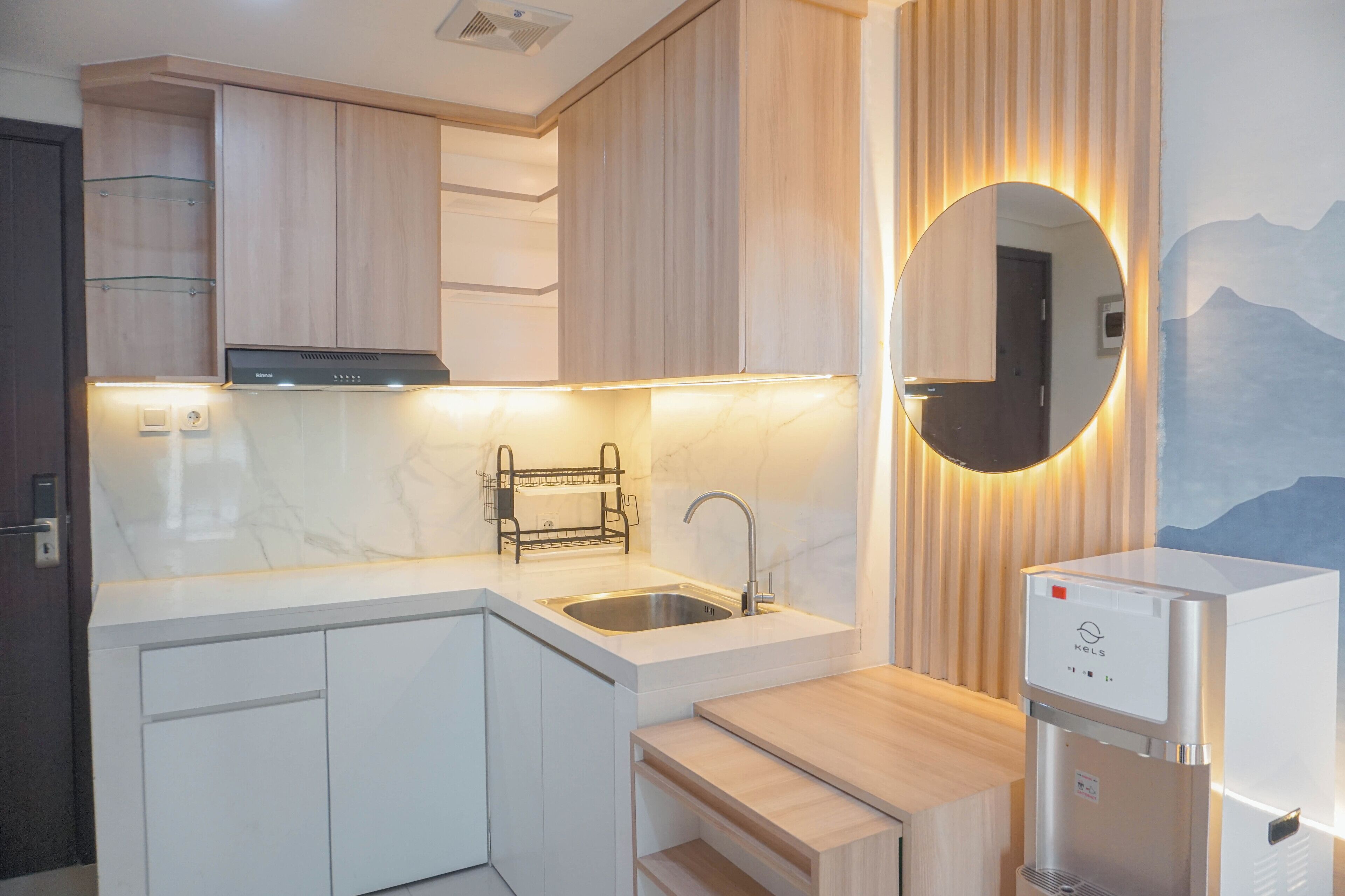 A modern kitchen with a built-in sink, a stainless steel range hood, and a water dispenser.