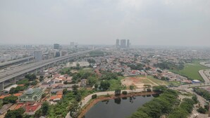A cityscape with a prominent bridge, residential areas, and a large body of water.