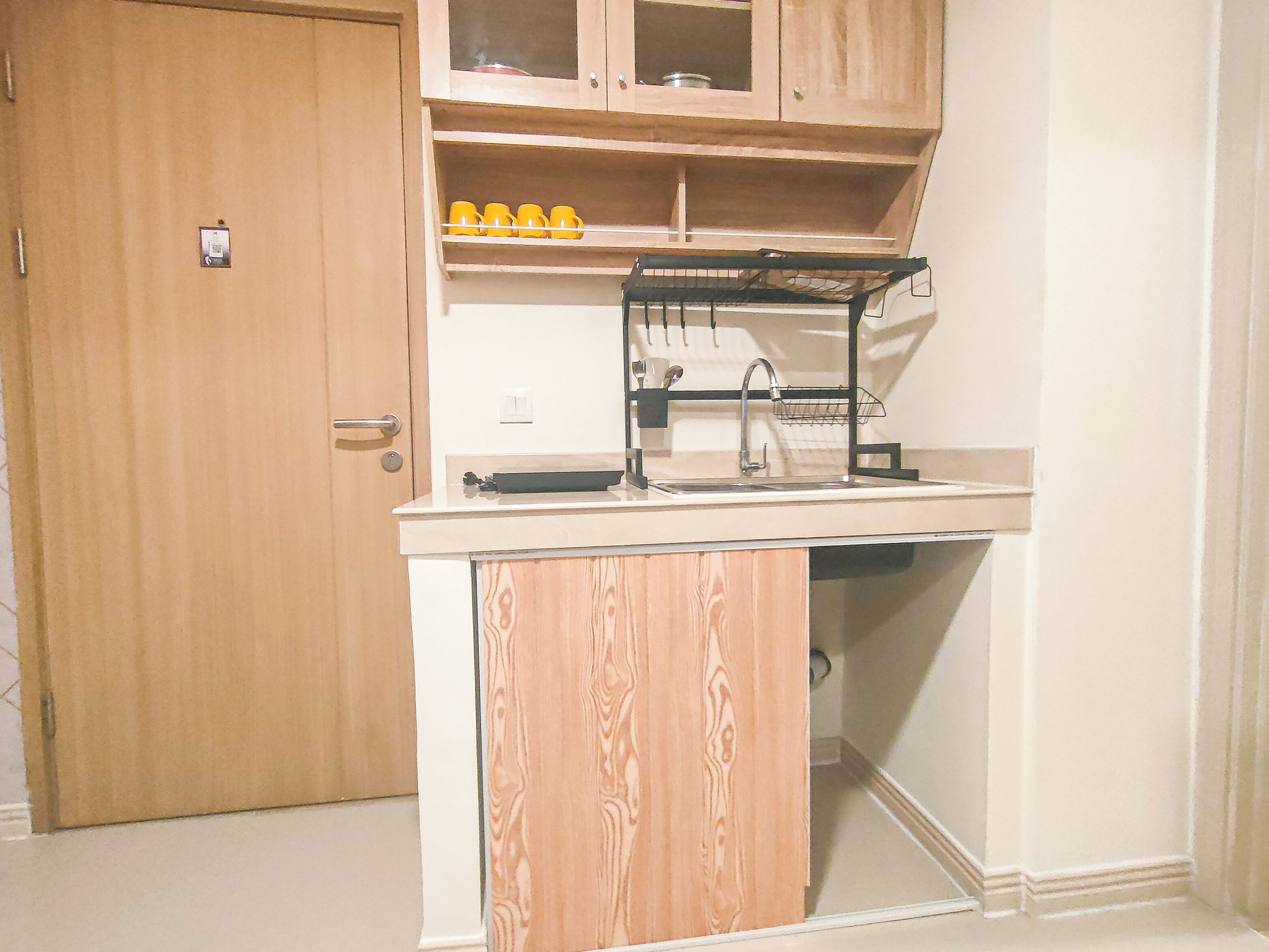 Una cocina funcional con armarios de madera, un lavamanos y un tendedero.