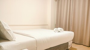 A neatly made bed with white linens and two rolled towels on the side. - Marvelous And Cozy 2Br At Meikarta Apartment (Cikarang)
