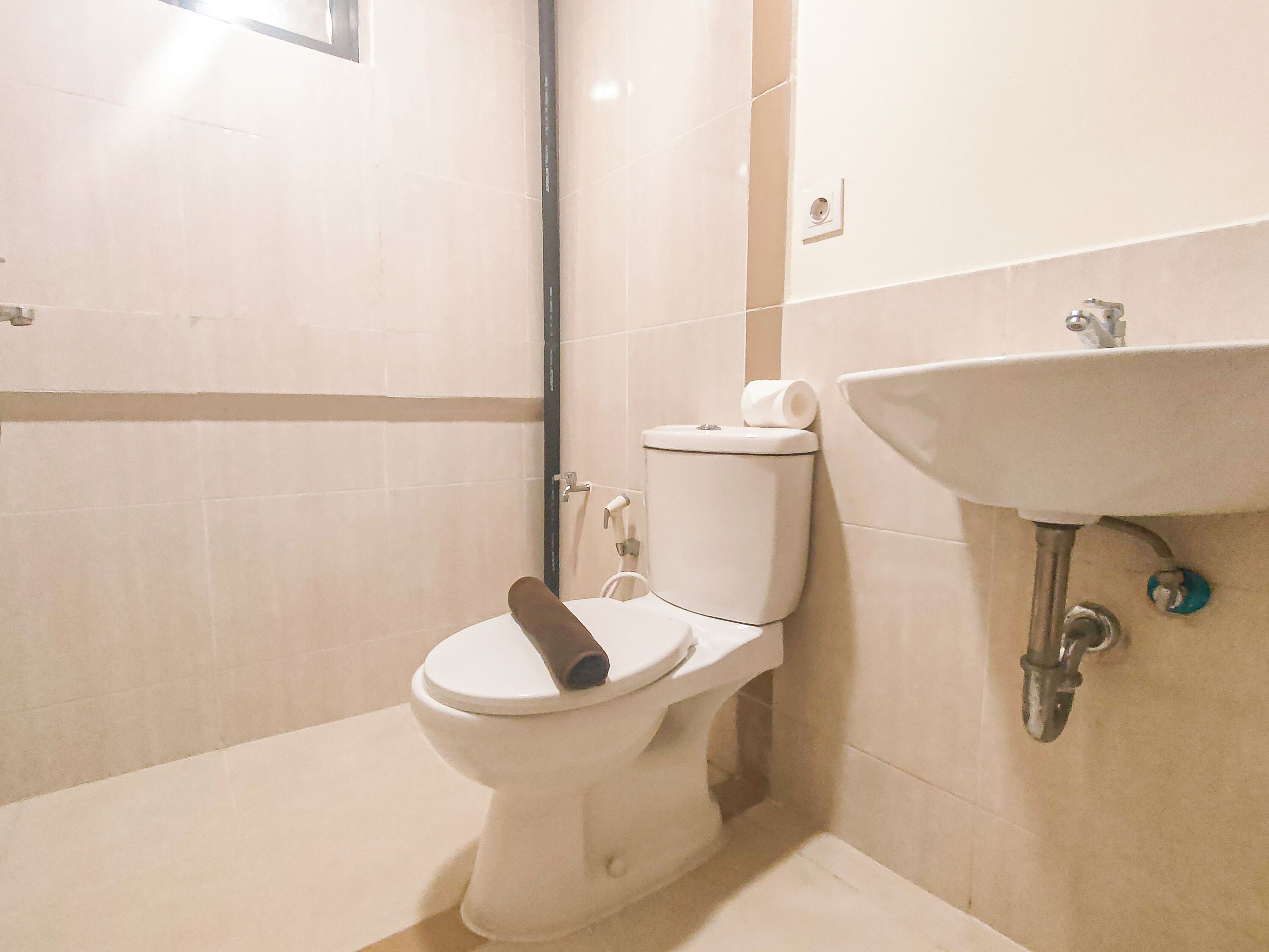 Une salle de bain comprenant des toilettes, un lavabo et un espace douche.