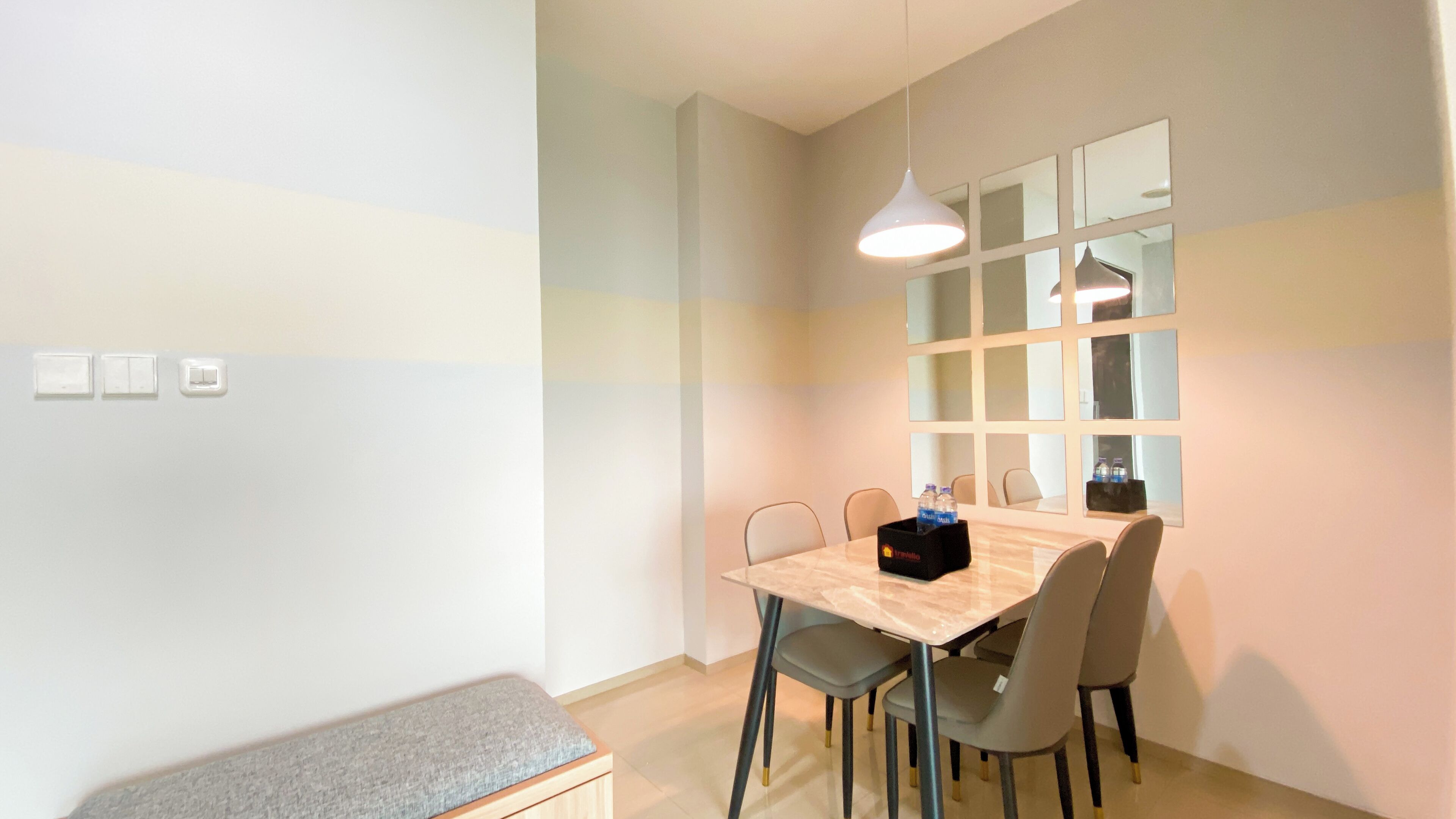A dining area with a table, chairs, a bench, and a window with blinds.