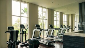 A gym with treadmills, elliptical machines, and a weight bench. - Cozy And Enjoy Living 1Br At Citralake Suites Apartment (Jakarta)