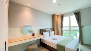 A modern hotel room with a large bed, a bedside table, a mirror, and a window with curtains. - Cozy And Enjoy Living 1Br At Citralake Suites Apartment (Jakarta)