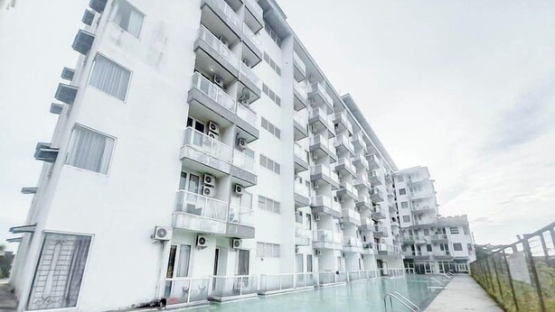 A modern multi-story residential building with balconies, a swimming pool, and a gated entrance. - Best Deal Studio Apartment At Vivo Yogyakarta (Depok)