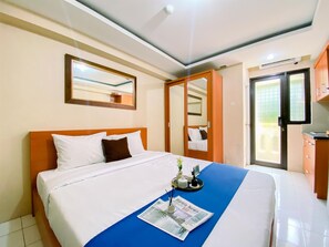 Relax in this inviting room with a comfortable bed, a stylish table, and a large mirror.