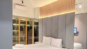 Un dormitorio moderno con una cama grande, un armario empotrado y una mesita de noche.