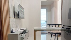 Una cocina moderna con estufa integrada, una pequeña mesa de comedor y un taburete de bar.