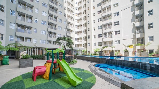 A residential building with a pool, a children's play area, and a well-maintained garden. - Simply And Cozy 2Br Apartment At Parahyangan Residence (Bandung)