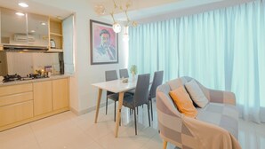 Una cocina moderna con comedor, sofá y un amplio ventanal con cortinas.