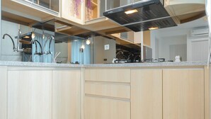 Una cocina moderna con armarios de madera, electrodomésticos de acero inoxidable y encimera de granito.