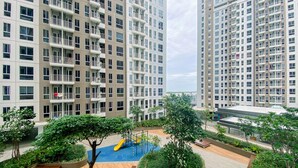 A residential building with multiple balconies, a playground, and surrounding greenery. - Relaxing and Comfortable Studio at Tokyo Riverside PIK 2 Apartment  (Teluknaga)