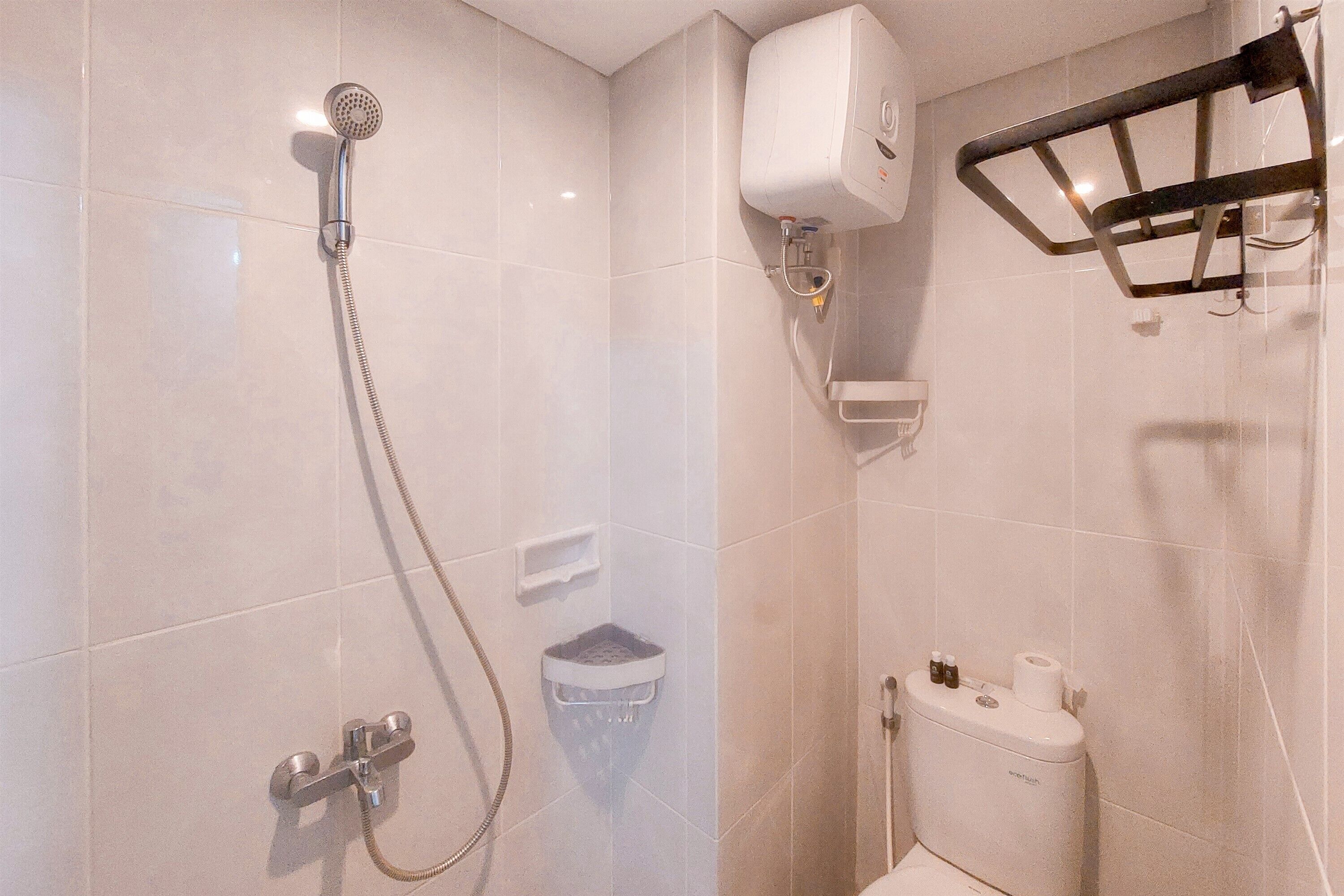 Une salle de bain équipée d’une douche, de toilettes et d’un sèche-mains.