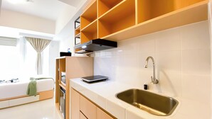 Una cocina moderna con horno empotrado, pileta de acero inoxidable y una tableta sobre la encimera.