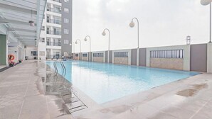 An indoor swimming pool with a clear view of the surrounding buildings and a covered walkway. - Spacious 3Br At Mekarwangi Square Cibaduyut Apartment (Bandung)