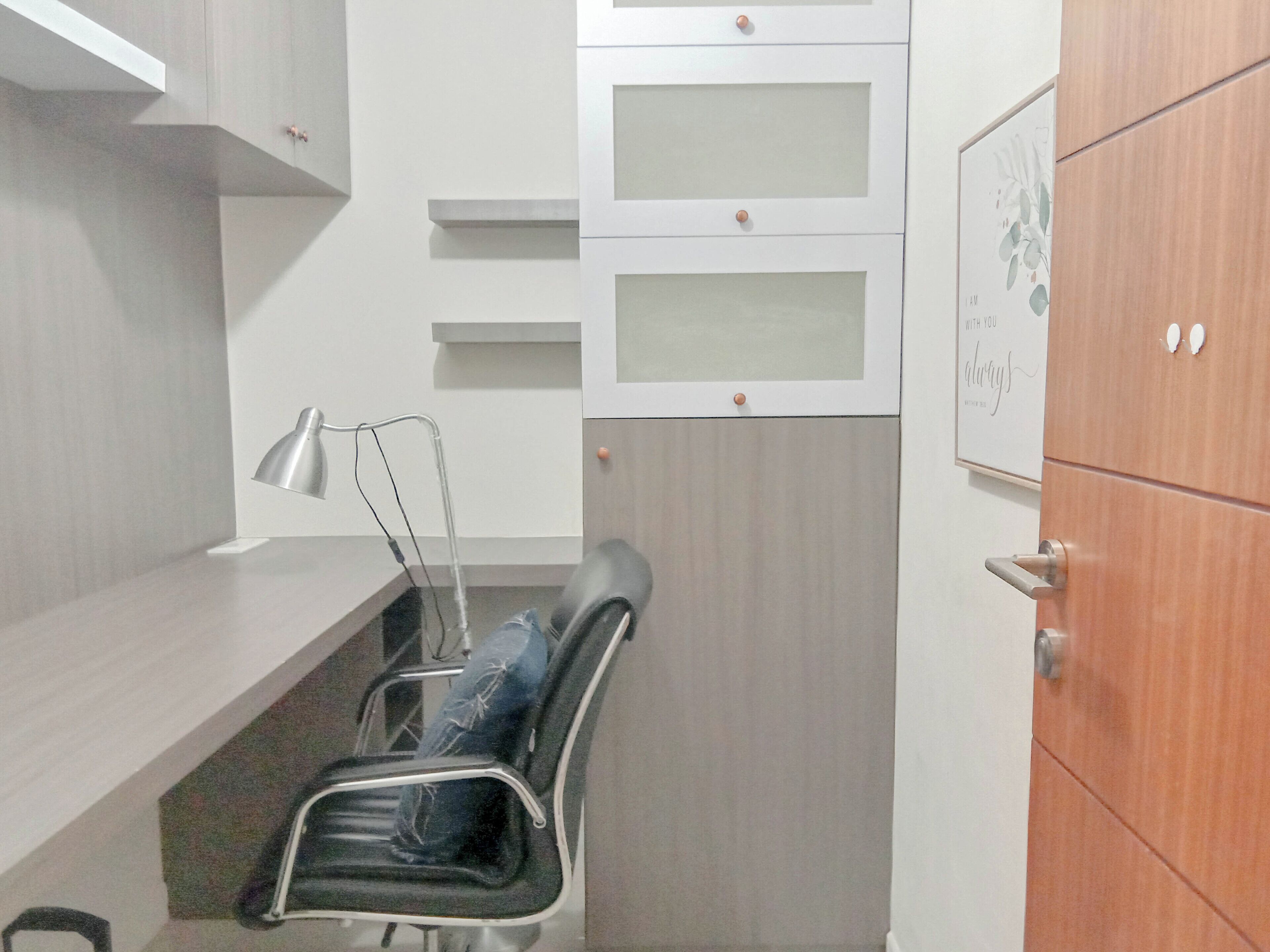 Ein kleiner Arbeitsraum mit Schreibtisch, Stuhl und Aktenschrank.