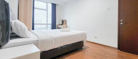 A modern bedroom with a bed, bedside table, and a view of the city through a large window.
