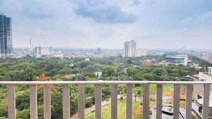 A cityscape with high-rise buildings, greenery, and a clear sky.