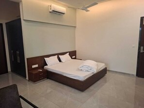 Ein Schlafzimmer mit einem Bett, Nachttischen, einer Klimaanlage und einem Kleiderschrank.