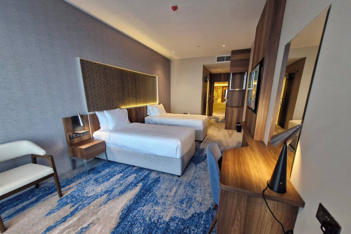 Une chambre d’hôtel moderne équipée d’un grand lit, d’un bureau, d’une chaise et d’un téléviseur.