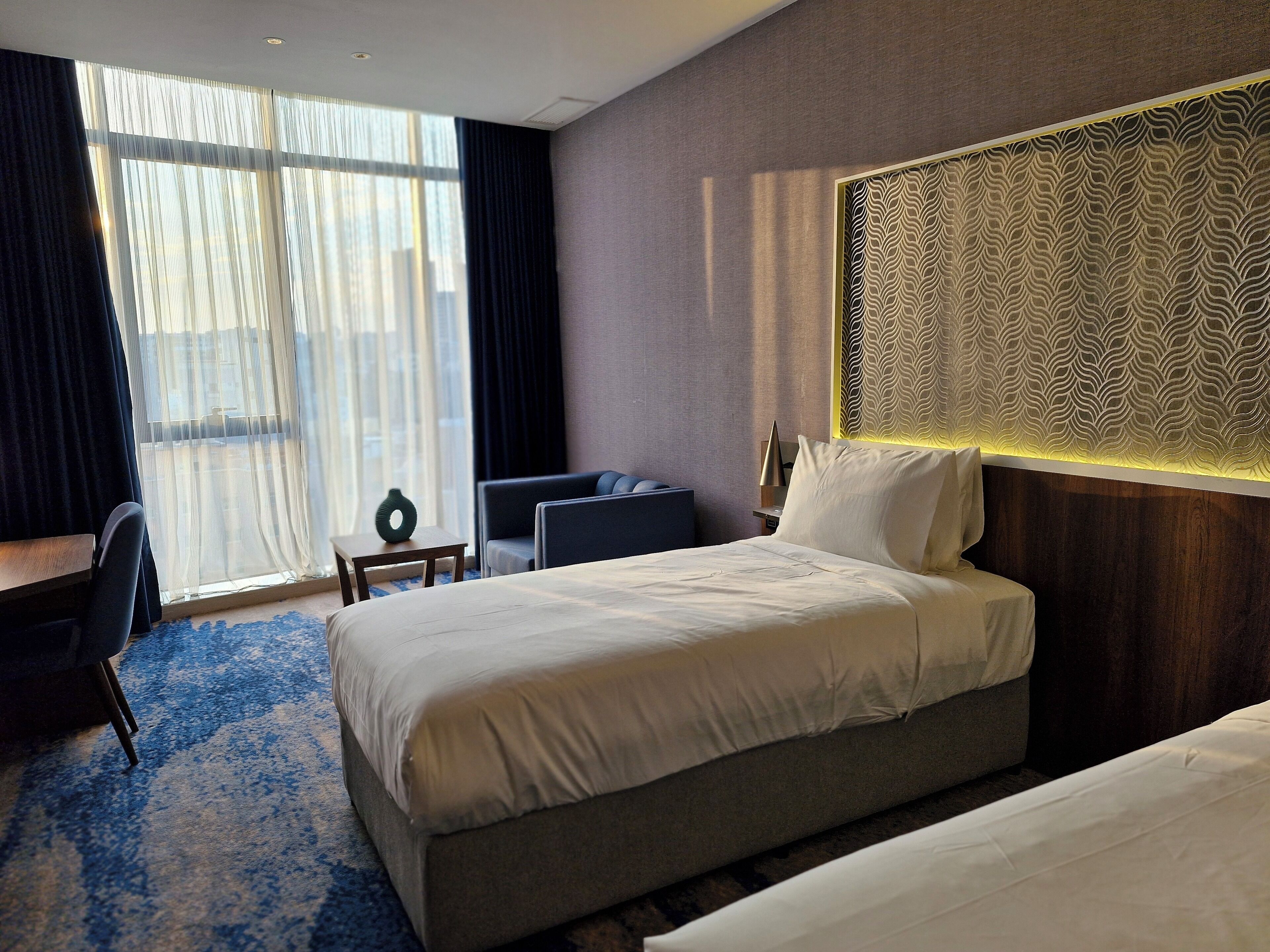 Una habitación de hotel con una cama grande, un escritorio y una silla.
