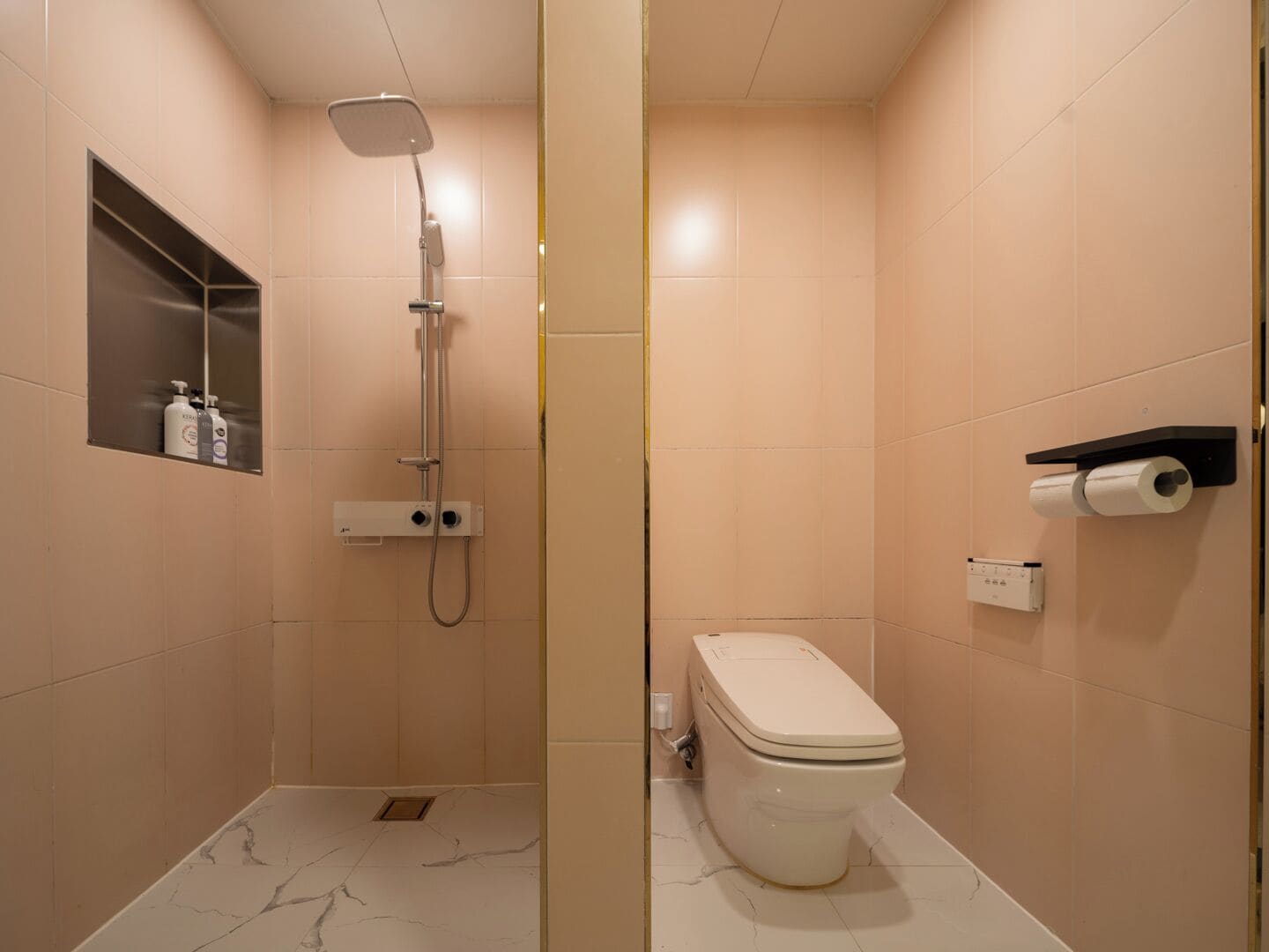 Baño con ducha, inodoro y estante con artículos de aseo.