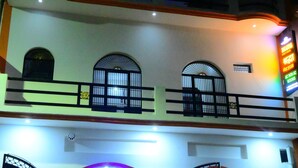 A hotel with a balcony, arched windows, and a sign indicating guest rooms. - Shraddha Guest House (Ayodhya)