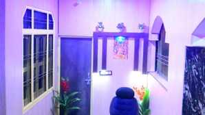 A room with a desk, a chair, a door, and a window with bars. - Shraddha Guest House (Ayodhya)
