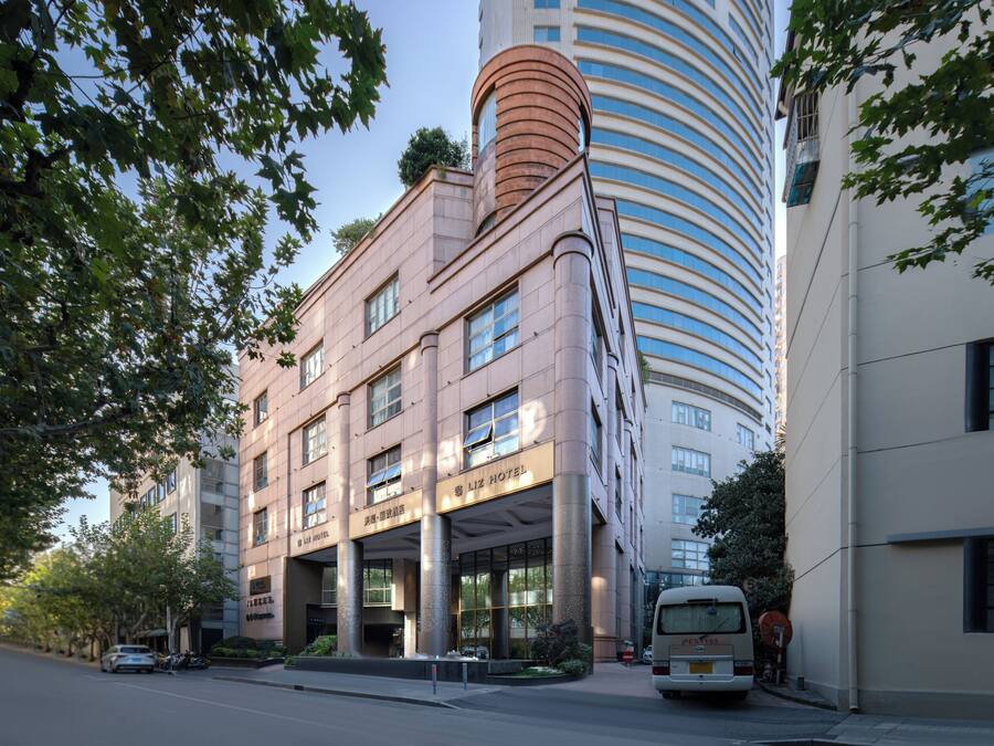 Un hotel con fachada moderna, amplias ventanas y una entrada destacada.