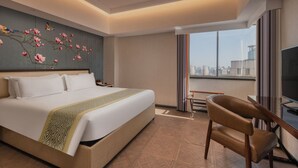 A hotel room with a large bed, a chair, a TV, and a city view. - MEHOOD LESTIE Hotel (Shanghai Xujiahui Wukang Road) (Shanghai)