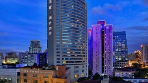 A modern hotel with a curved facade, multiple floors, and illuminated windows. - MEHOOD LESTIE Hotel (Shanghai Xujiahui Wukang Road) (Shanghai)