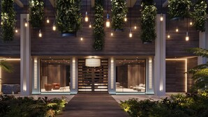 A modern hotel entrance with a wooden facade, large glass doors, and a central light fixture. - Grand Hyatt Grand Cayman Resort & SPA (Seven Mile Beach)