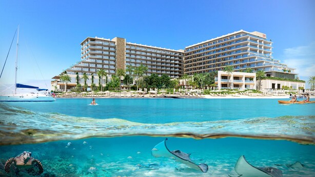 Un hotel grande con varios balcones con vista a una playa y al océano.