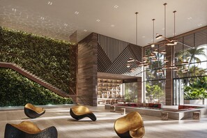 A modern interior with a staircase, seating area, and a wall with vertical greenery.
