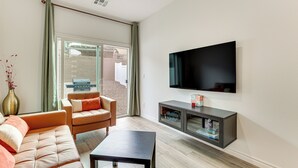 A modern living room with a sofa, a coffee table, and a TV mounted on the wall.