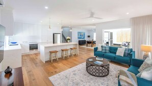 A modern living space with a kitchen, dining area, and a cozy seating area with a sofa and a coffee table.