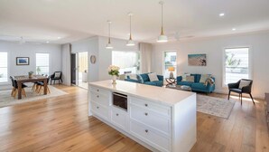 A spacious living area with a central island, a dining table, and a sofa set.