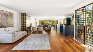 Un amplio salón con un tapete grande, un sofá y una zona de comedor.