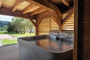 A hot tub under a wooden roof with a view of a green landscape. - ✨ Chalet Marcel – Luxury Chalet with Hot Tub, Sauna & Forest Setting (Gérardmer)