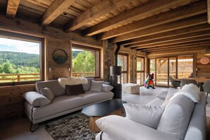 A cozy cabin interior with a sofa, a coffee table, and a fireplace.