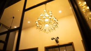A chandelier with multiple light fixtures hanging from the ceiling. - SAMBHAV VILLAS (Pushkar)