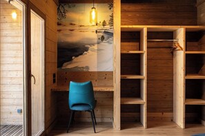 A wooden interior with a chair, shelves, and a mural of a snowy landscape.