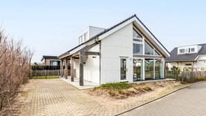 A modern two-story house with a sloped roof, large windows, and a covered patio area. - Duinzicht Renesse by Interhome (Renesse)
